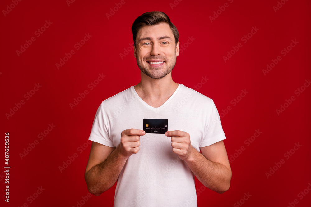 Portrait of young person hands holding banking card toothy smile isolated on burgundy color background Portrait of young person hands holding banking card toothy smile isolated on burgundy color background