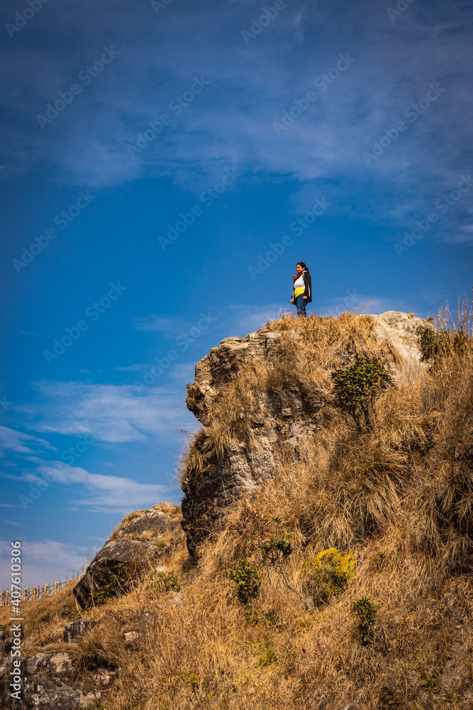 girl watching the beautiful mountain range from edge of mountain