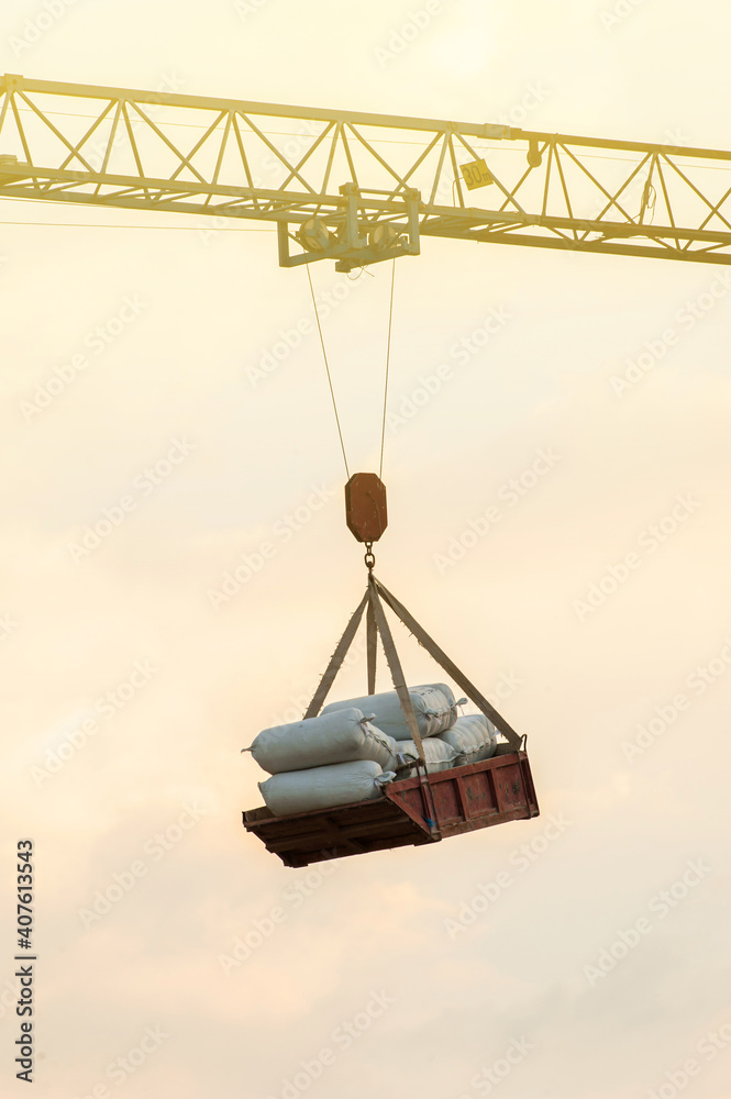 Hammerhead crane lifting tray of cement bags. Hammerhead crane lifting tray of cement bags.