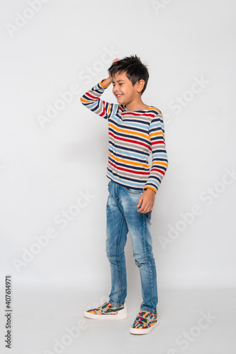 Bilde på lerret Young boy  laughs at himself, his forgetfulness, awkwardness against  gray backg