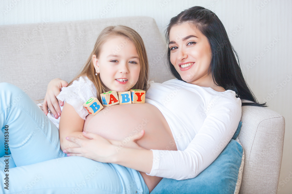 Young pregnant mother and her first child indoors Young pregnant mother and her first child indoors