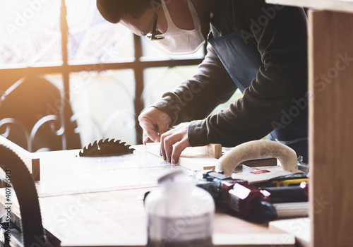 Woodworking practitioners use saw blades to cut wood pieces to assemble and build wooden tables for their clients. photo