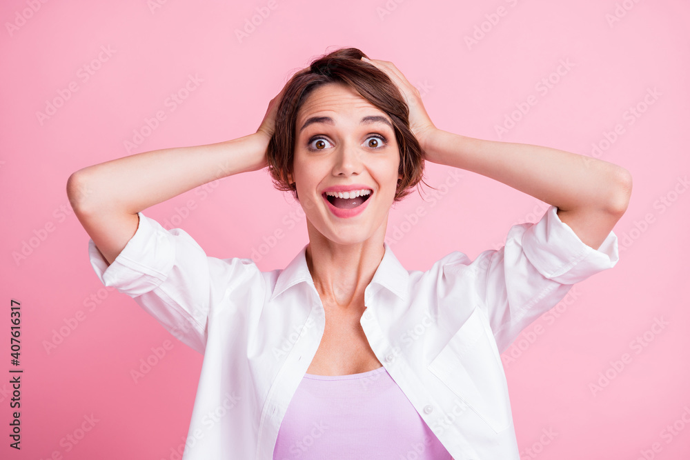 Photo portrait of happy surprised female student smiling keeping head with hands isolated on pink pastel color background Photo portrait of happy surprised female student smiling keeping head with hands isolated on pink pastel color background