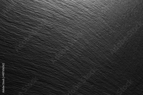 textured black slate background with spot of light