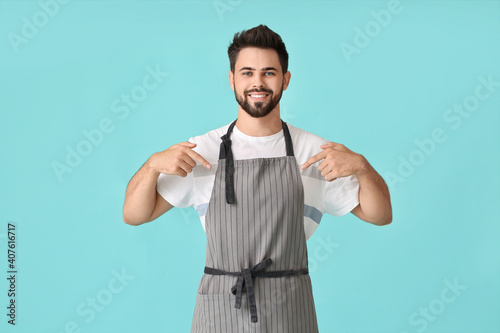 Young man in apron on color...
