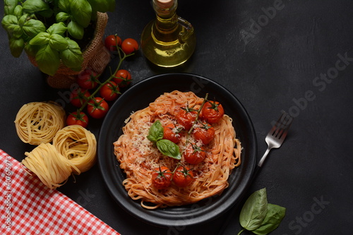 Spaghetti pasta with cherry tomatoes garnished with basil leaf