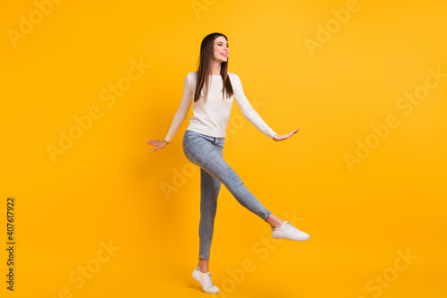 Fototapeta Naklejka Na Ścianę i Meble -  Full size photo of optimistic girl dance wear sweater jeans sneakers isolated on yellow color background