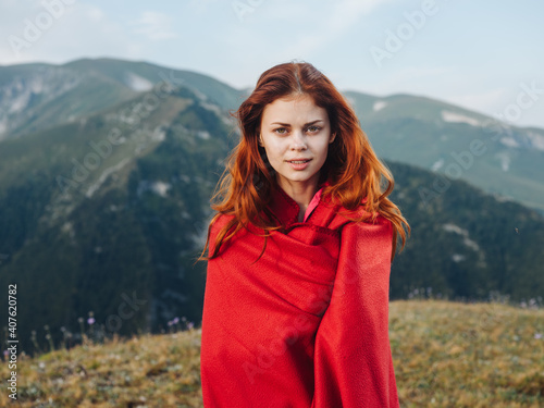 Romantic woman hiding behind a red plaid in the mountains outdoors in nature © SHOTPRIME STUDIO