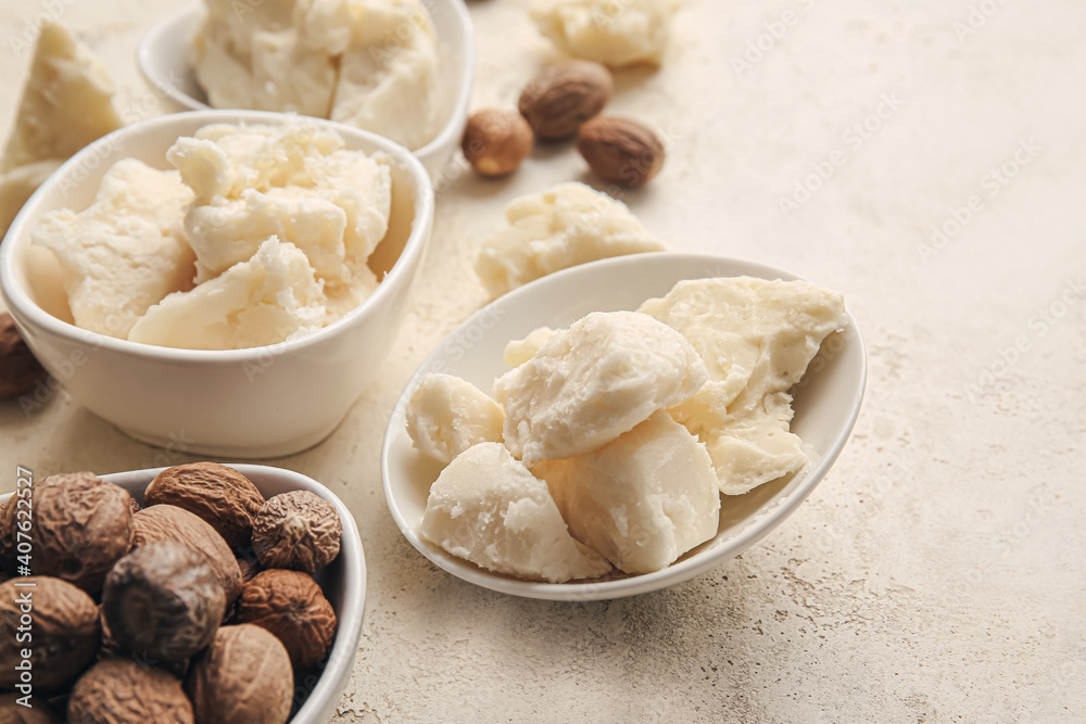 Shea butter and nuts on light background Shea butter and nuts on light background