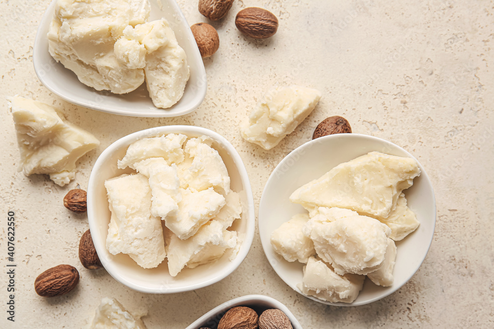 Fototapeta premium Shea butter and nuts on light background