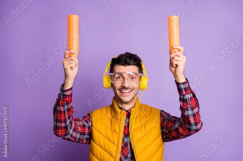 Photo of funny man aircraft marshaller wear yellow sleeveless jacket earphones eyewear holding lights isolated violet color background photo