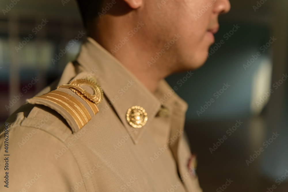 Thai Government Officer, Civil Servant wears Brownish-Yellow uniform.