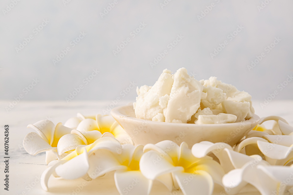 Plate with shea butter and flowers on table Plate with shea butter and flowers on table