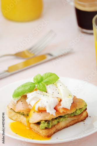 Breakfast with a sandwich with poached egg and avocado