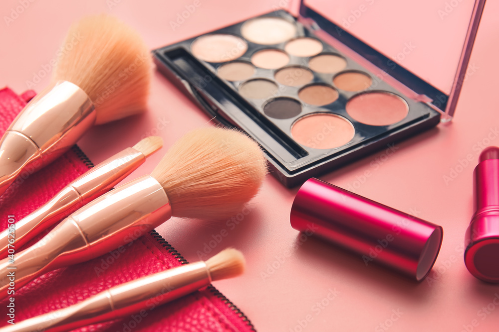 Bag with makeup brushes and cosmetics on color background Bag with makeup brushes and cosmetics on color background