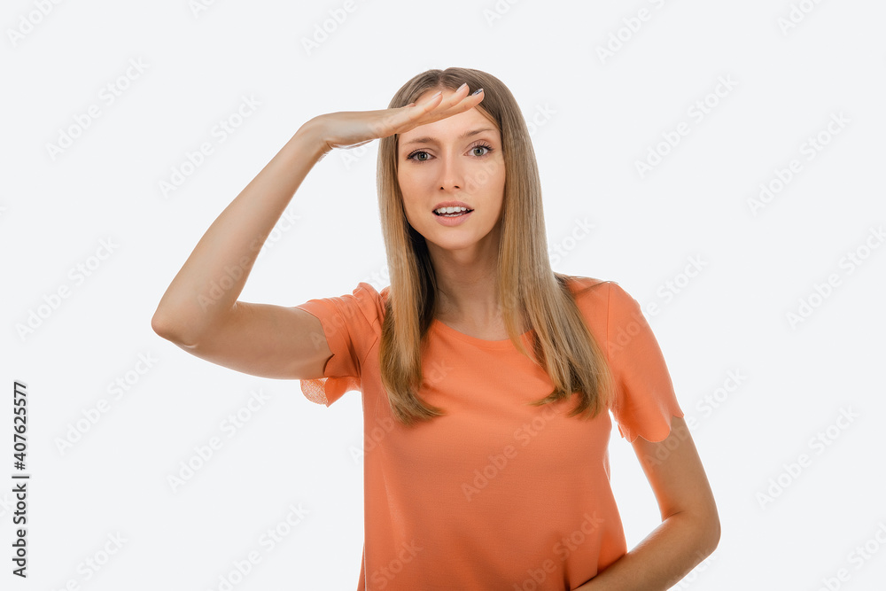 Portrait of a curious blond girl looking far away with hand at her forehead, trying to see something far away Portrait of a curious blond girl looking far away with hand at her forehead, trying to see something far away
