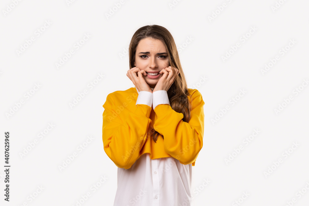Portrait of scared girl hold hands near mouth trembling fear, very terrified over scary creepy sound Portrait of scared girl hold hands near mouth trembling fear, very terrified over scary creepy sound