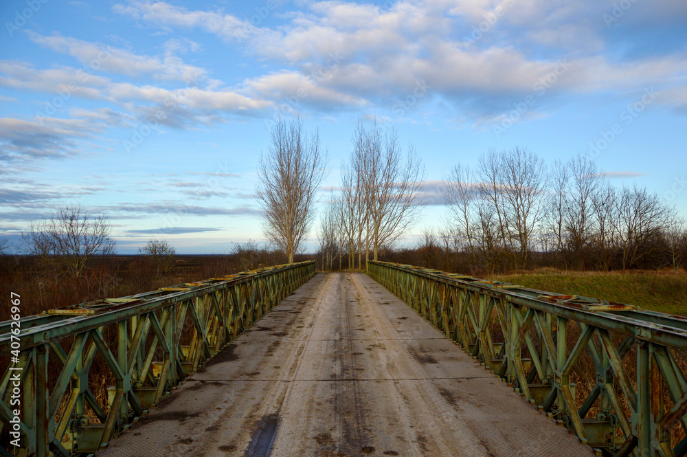 old rusty bridge with blue sky and white clouds