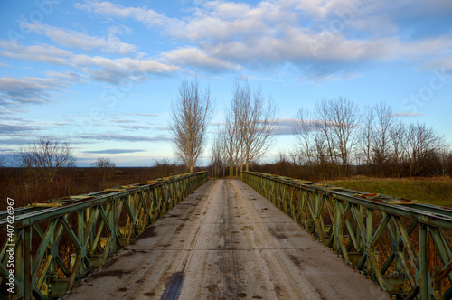 Fototapeta Naklejka Na Ścianę i Meble -  old rusty bridge with blue sky and white clouds