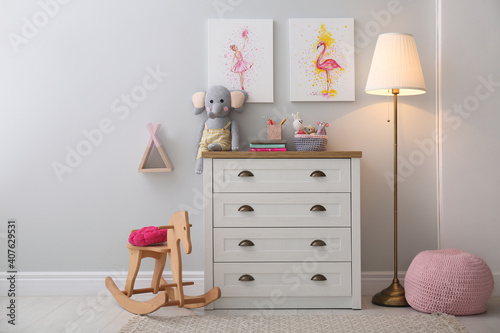 Chest of drawers and beautiful pictures in children's room. Interior design © New Africa
