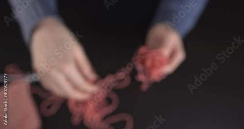 A woman unravels the tangled yarn for knitting.