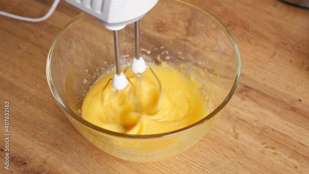 Mixer beats eggs in a glass bowl. Mixer beats eggs in a glass bowl.