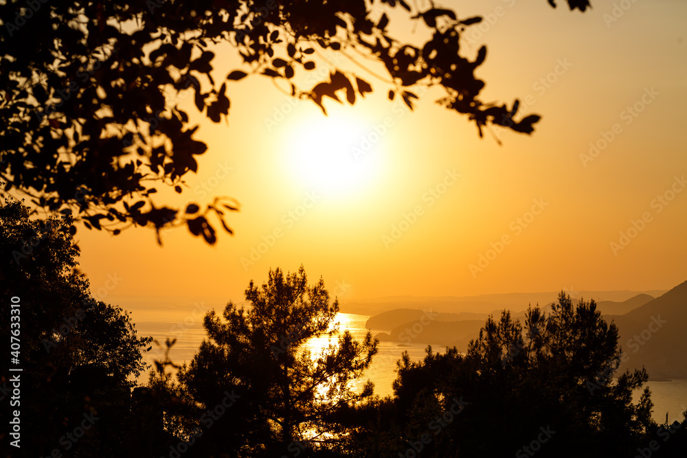 The sun sets on the horizon at sunset over the sea or ocean. Calm ocean sea waves. Natural sky in warm colors. Panoramic view,