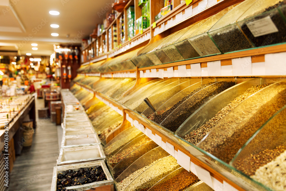 A counter with a variety of colorful spices in the store. Perspective.