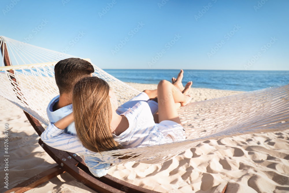Naklejka premium Couple relaxing in hammock on beach. Summer vacation