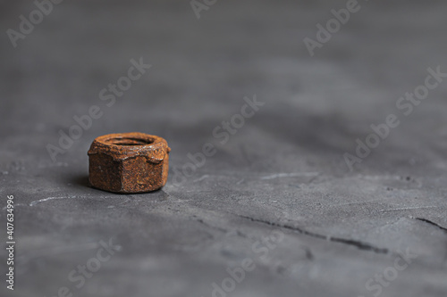 Old rusty nut close-up on a dark gray background. Parts of industrial machines.