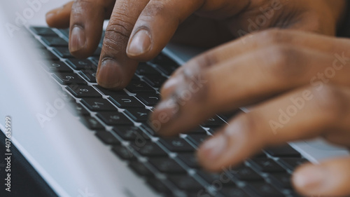 Close up, hands of a black man typing on the laptop keyboard. remote work concet. High quality photo