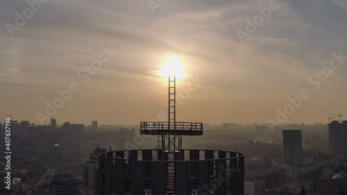 silhouette of a roof spire  lightning rod in a skyscraper. against the backdrop of sunset and evening city center