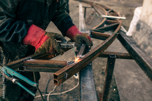 A worker welds metal for a canopy.