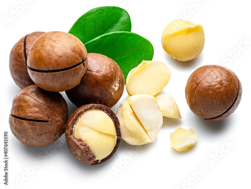 Macadamia nuts with peeled macadamia and leaves isolated on a white background.