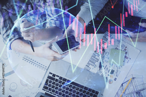 Double exposure of forex graph drawing and man and woman working together holding and using a mobile device. Trade concept.