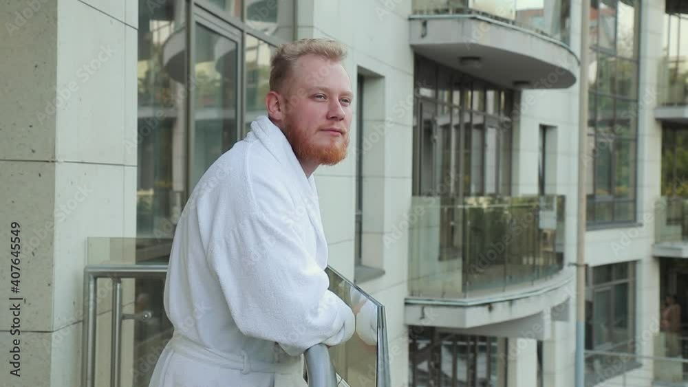 young man with beard and in a robe rest on a hotel balcony on vacation young man with beard and in a robe rest on a hotel balcony on vacation