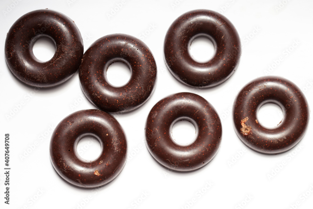 Raw vegan homemade chocolate candy balls on a white background. Top view in the form of donuts Raw vegan homemade chocolate candy balls on a white background. Top view in the form of donuts