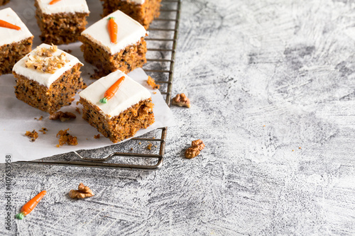 pieces of carrot cake with walnuts with icing cream on a light background. tinting. selective focus