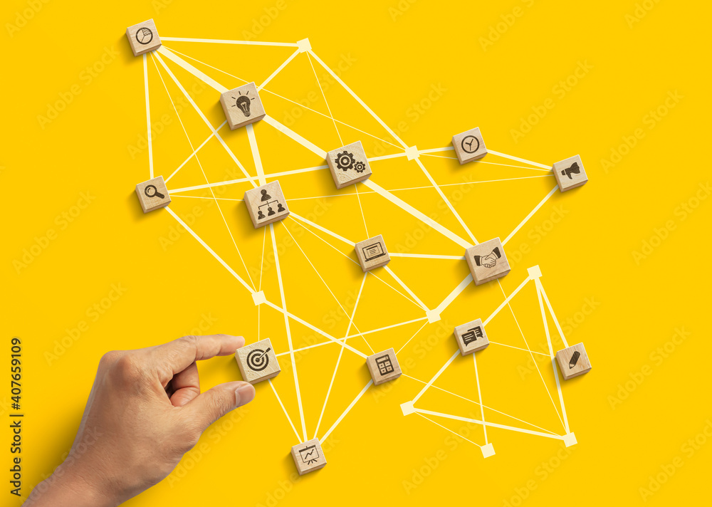 Business strategy to success, business management or start up business concept. Hand is arranging wooden blocks with business icon in low polygon rocket shape network on yellow background. Business strategy to success, business management or start up business concept. Hand is arranging wooden blocks with business icon in low polygon rocket shape network on yellow background.
