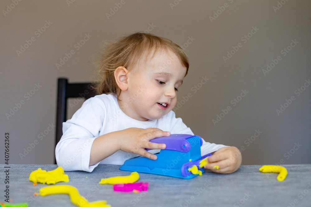Cute little boy moulds from colored plasticine on table. Home schooling. Creative leisure with children during corona virus quarantine staying at home. Cute little boy moulds from colored plasticine on table. Home schooling. Creative leisure with children during corona virus quarantine staying at home.