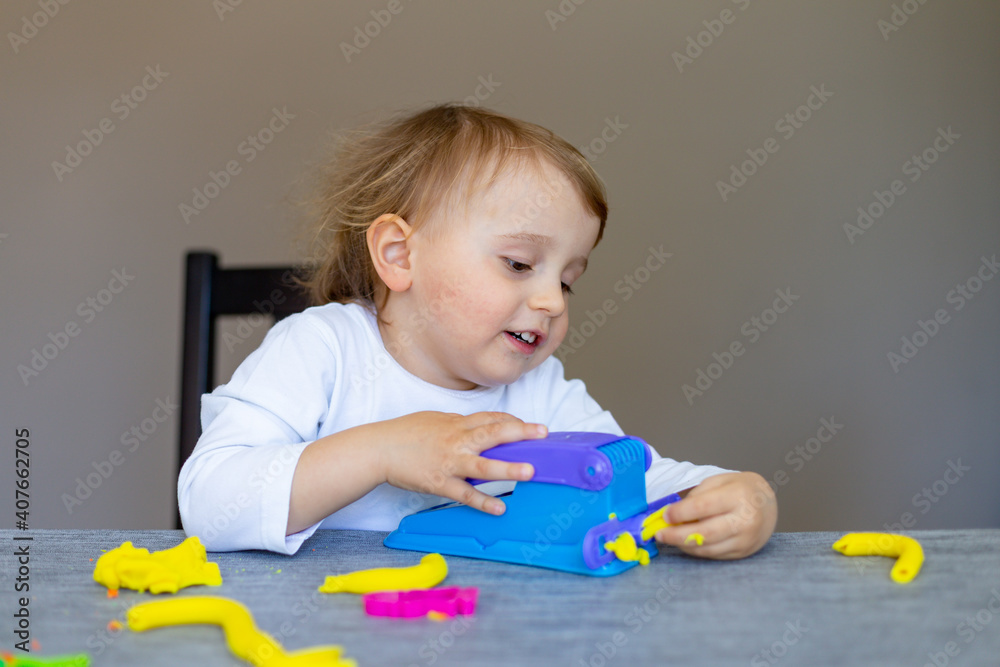 Cute little boy moulds from colored plasticine on table. Home schooling. Creative leisure with children during corona virus quarantine staying at home. Cute little boy moulds from colored plasticine on table. Home schooling. Creative leisure with children during corona virus quarantine staying at home.