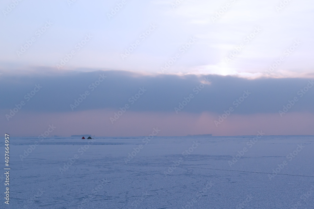 Two tents on a frozen thief. Winter fishing concept. Winter in Eastern Europe. Landscape. Horizontal orientation.