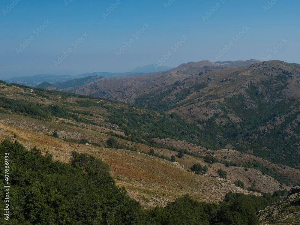 Mountain landscape in Gennargentu, highest mountain in Sardinia, Nuoro, Italy. Vaste peaks, dry plains and valleys with mediterranean vegetation. Late summer, blue sky