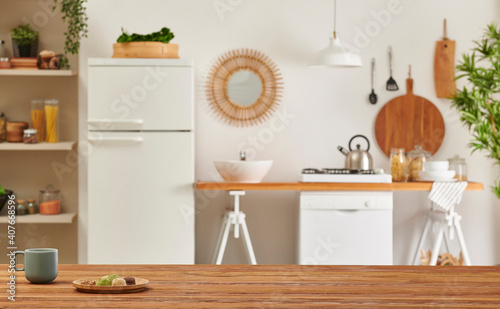 Close up wooden table and decorative kitchen background style. Refrigerator, dishwasher and stove style with lamp concept. © UnitedPhotoStudio