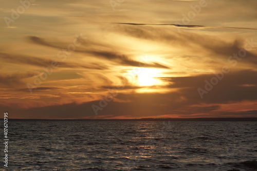 Calm sea at sunset. The water has no big waves and the sky is coloured. The water is dark. © Viktor Yurkin