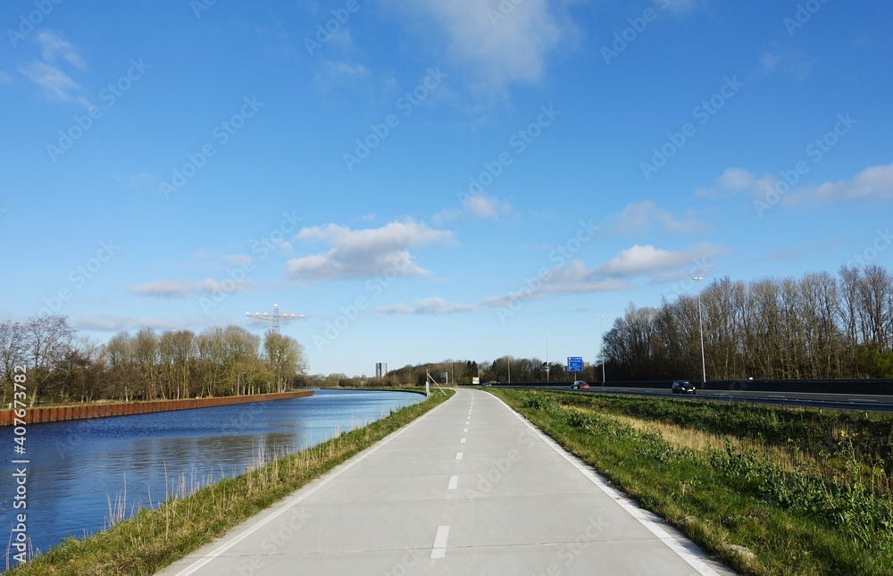 Cycle highway in between a canal and a highway near the city of Groningen for sustainable transportation on bicycles.