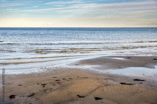 Wet sand beach, calm waves and view over the water to the horizon on the Baltic Sea in northern Germany, copy space