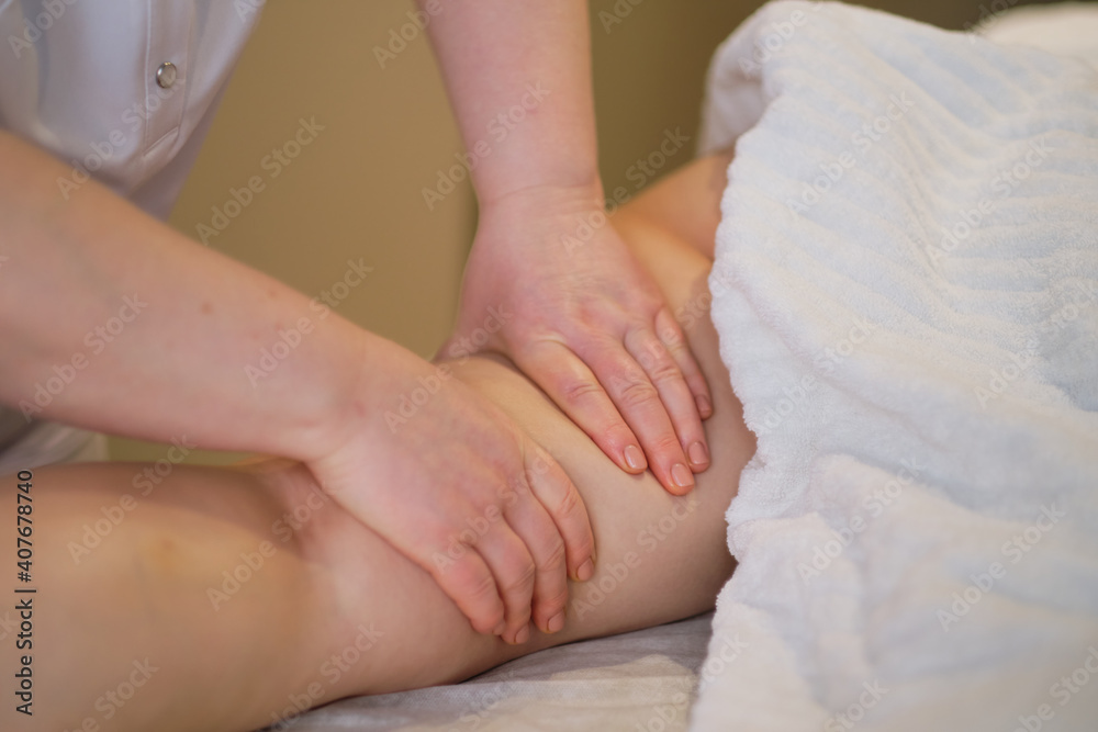 Detail of hands massaging human calf muscle.Therapist applying pressure on female leg. Hands of massage therapist massaging legs of young woman in spa salon. Body care in spa salon for young woman. Detail of hands massaging human calf muscle.Therapist applying pressure on female leg. Hands of massage therapist massaging legs of young woman in spa salon. Body care in spa salon for young woman.