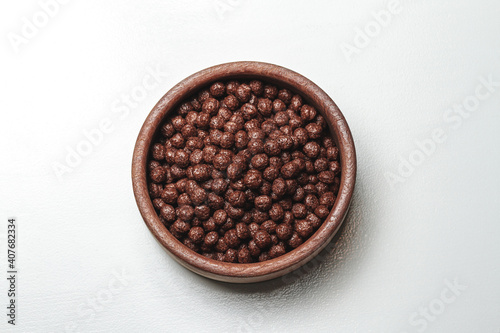 Wooden bowl with chocolate quick breakfast cereal on white background