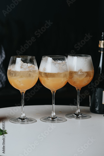 Cocktails with champagne in wine glasses on the bar table in the pub or restaurant with the bartender. 